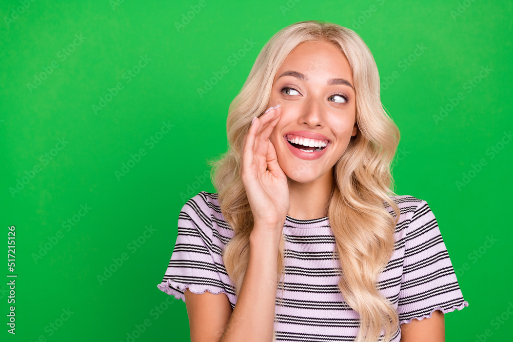 Portrait of cheerful nice person arm palm near open mouth look empty space tell isolated on green color background Portrait of cheerful nice person arm palm near open mouth look empty space tell isolated on green color background