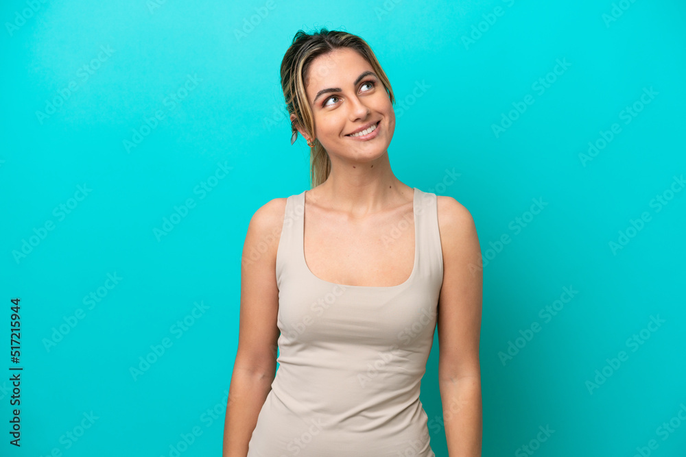 Young caucasian woman isolated on blue background thinking an idea while looking up Young caucasian woman isolated on blue background thinking an idea while looking up