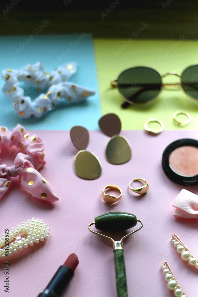 Various accessories, make up products and jewelry on various colorful pastel backgrounds. Selective focus. Various accessories, make up products and jewelry on various colorful pastel backgrounds. Selective focus.