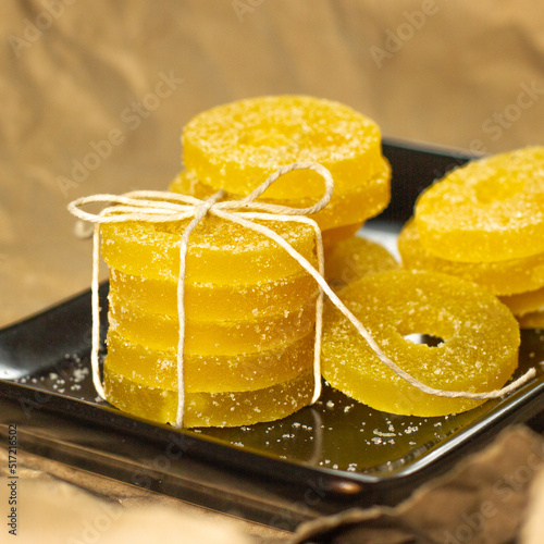 Lemon, orange and grapefruit slices in sugar isolated on a wooden background, close-up. Marmalade sweets. Sweets with citrus flavor. Candies