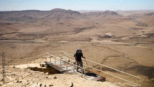 A static view of a male hiker on a steep trail ascending Mount Ardon. Ramon Crater, Negev Desert, Southern Israel photo