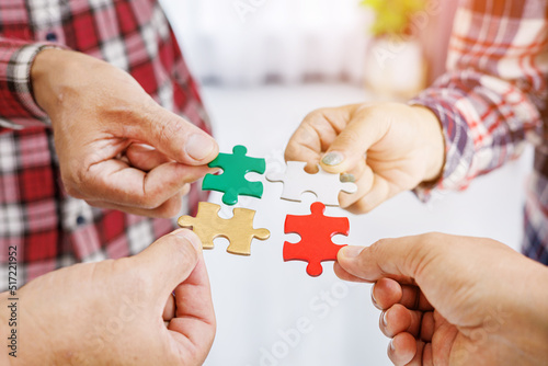 Close up Businesspeople hand holding jigsaw puzzle in a circle on the table, success and strategy concept.