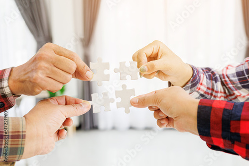 Close up Businesspeople hand holding jigsaw puzzle in a circle on the table, success and strategy concept.