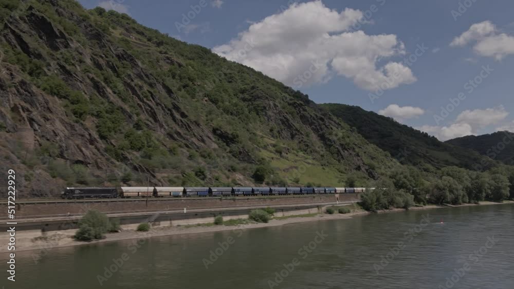 Freight Train Tracking shot with drone in the Rhine valley besides the mountain and river Freight Train Tracking shot with drone in the Rhine valley besides the mountain and river