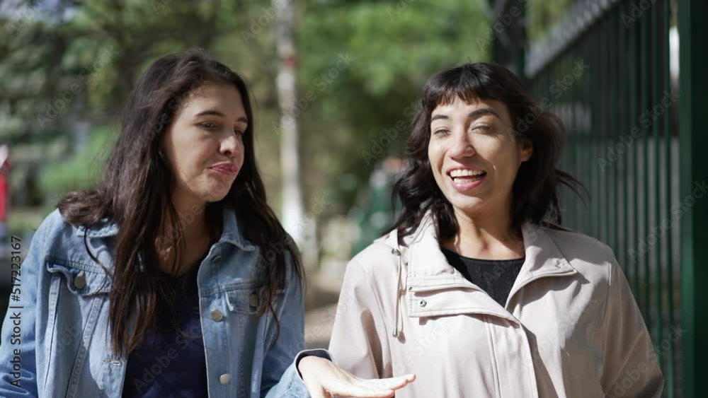 Two hispanic latin diverse woman walking outside in city street sharing gossip Two hispanic latin diverse woman walking outside in city street sharing gossip