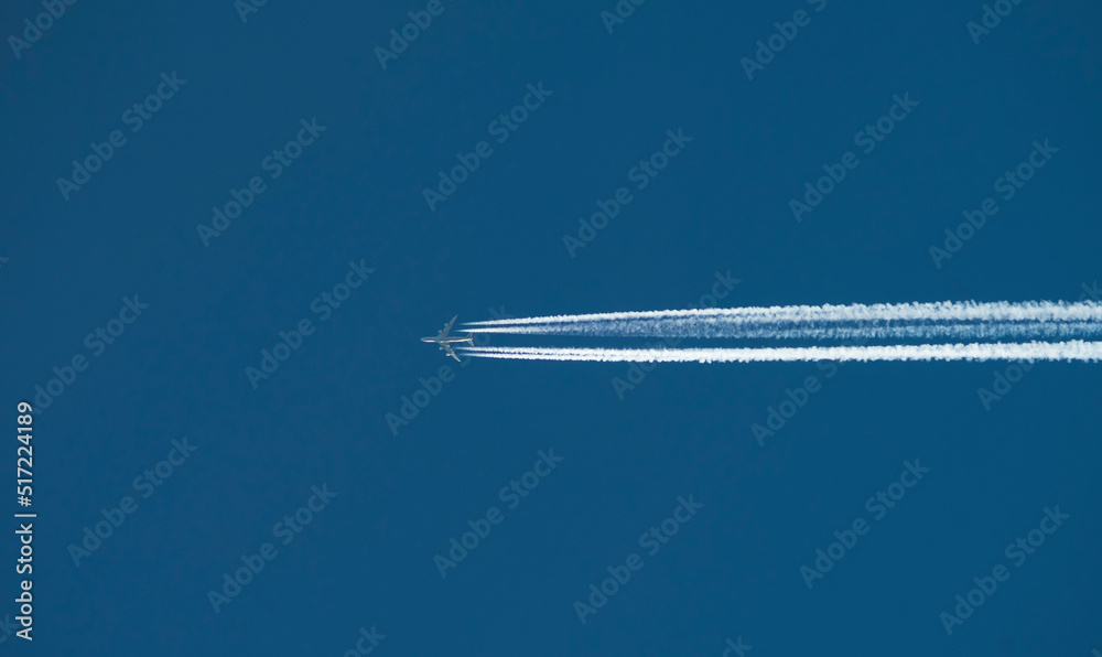 Airplane with a long reverse trail in the blue sky Airplane with a long reverse trail in the blue sky