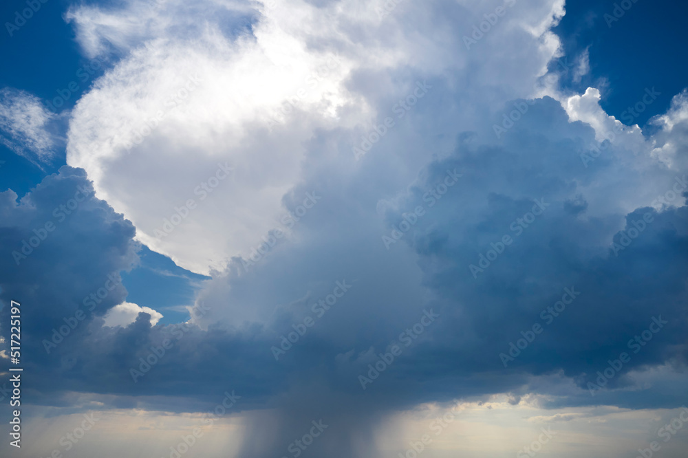 Blue sky with white hail clouds. The approach of an atmospheric front with thunderstorms, rain, hail and squally wind. Shooting from a drone.