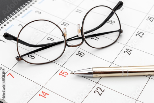 Pen with glasses on the calendar. Close up. Business concept.