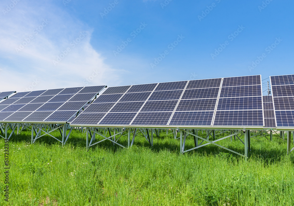 Solar panels on the green fields with blue sky background Solar panels on the green fields with blue sky background