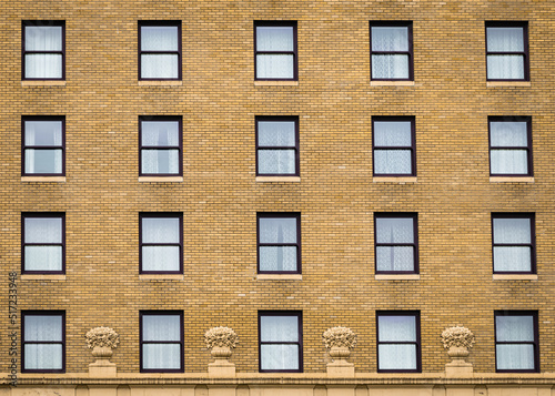 Many windows in row on facade of urban apartment building. Brick building. © Elena_Alex