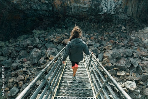 Fototapete Female descending metal stairs to a lava tube, Craters of the Moon, Idaho