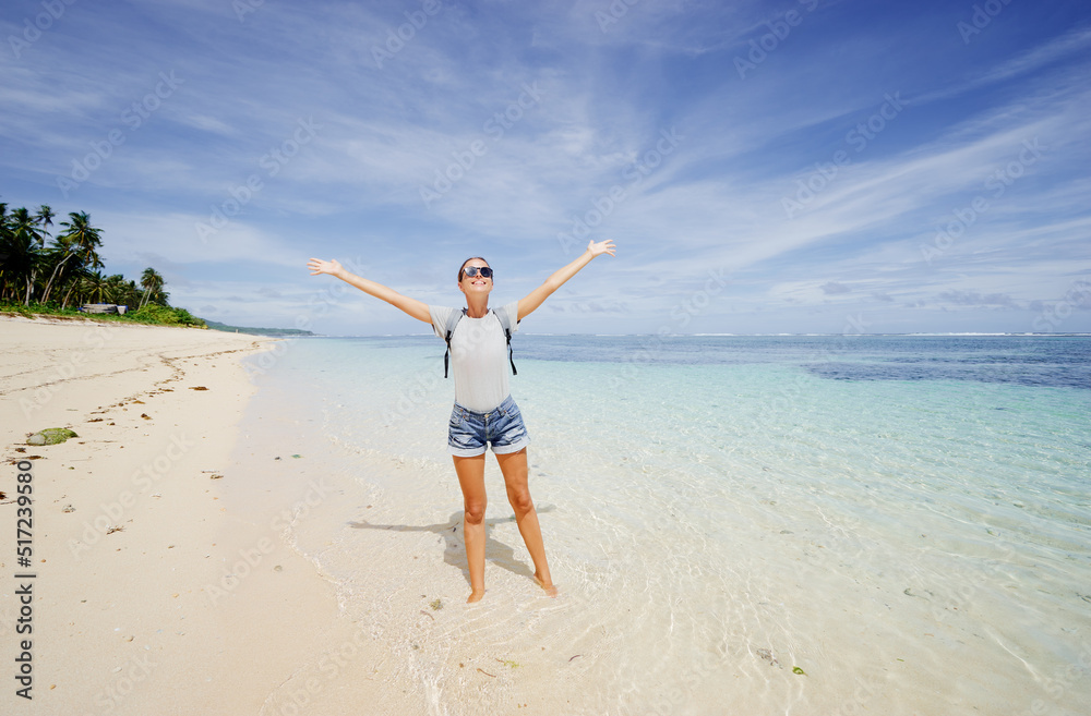 Vacation and freedom. Happy young woman rising hands up standing on tropical beach enjoying beautiful view. Vacation and freedom. Happy young woman rising hands up standing on tropical beach enjoying beautiful view.