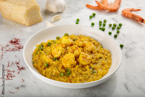 SAFFRON RISOTTO WITH SHRIMPS served in a dish isolated on grey background side view