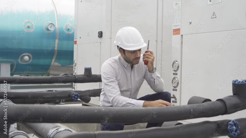 An engineer man or worker, people working in industry factory. Chiller tower on rooftop building. System work machine. Condenser Water Supply pipe lines. Ventilation compressor. Workshop site. An engineer man or worker, people working in industry factory. Chiller tower on rooftop building. System work machine. Condenser Water Supply pipe lines. Ventilation compressor. Workshop site.