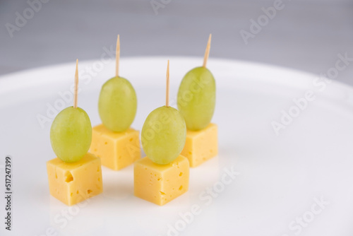  cheese and grape canapes on white plate or background closeup,snack concept