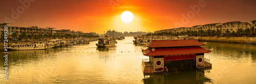 Tuan Chau Pier and Tuan Chau Water Puppet Theater at sunrise.Tourist boat cruise for Halong bay. Vietnam's important travel destination.  photo