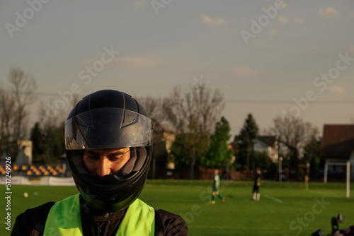 Заголовок  Motorcyclist in a driving lesson. Lessons in auto and motorcycle school. A student in a special uniform drives a motorcycle. Summer training on a moped. Student and teacher.   © Аня Марченко