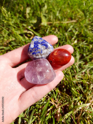 Amethyst, carnelian and lazurite natural mineral stones on the hand, gemstones for healing, altar, reiki, meditation, spiritual practice, ritual, witchcraft.