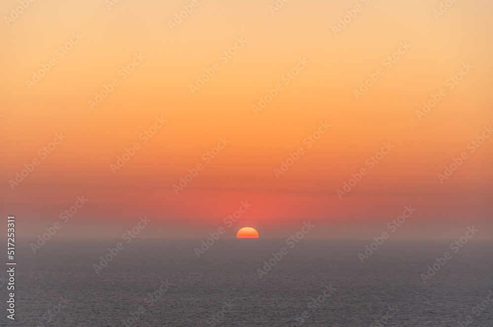 Coucher de soleil orange sur la mer grise