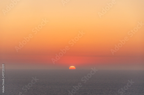 Coucher de soleil orange sur la mer grise