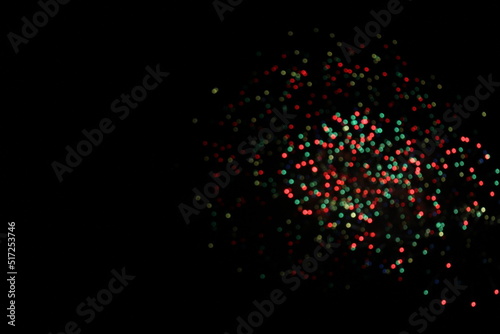 Red, green, gold and blue blurred Bokeh fireworks against a pitch black sky with copy space (Paris, France). Concept for celebration, festival, new year, christmas, Bastille Day, fireworks, etc.