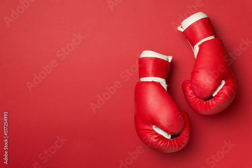 Red boxing gloves on color background, top view © Liami