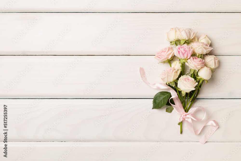 Small bouquet with rose flowers on wooden background, top view Small bouquet with rose flowers on wooden background, top view