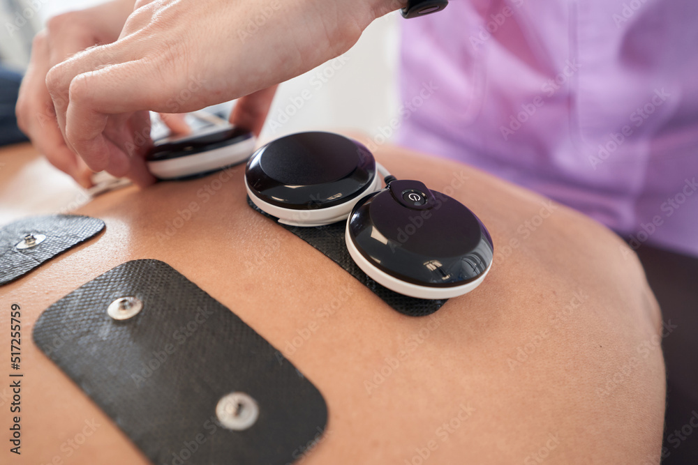 Fototapeta premium Male patient receiving myostimulation treatment in clinic