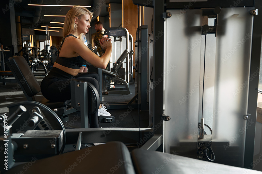 Fototapeta premium Fit lady doing leg workout in fitness studio