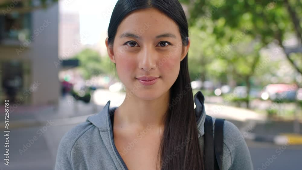 Portrait of a happy asian woman out traveling in the city. Young female student or backpacker smiling while standing against a urban background. Face of a tourist out on a solo adventure exploring Portrait of a happy asian woman out traveling in the city. Young female student or backpacker smiling while standing against a urban background. Face of a tourist out on a solo adventure exploring