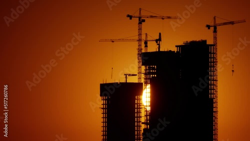Timelapse. a big orange sun sets in the city