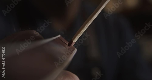 Macro view of a match being lit on a matchbox held by the hand of a caucasian man, 4K Super Slow motion, 240fps, macro shot, Apple prores HQ