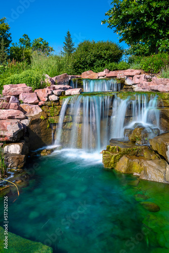 Long exposure photography of flowing water and waterfall at the public park arboretum in East Sioux Falls Historic Site, South Dakota