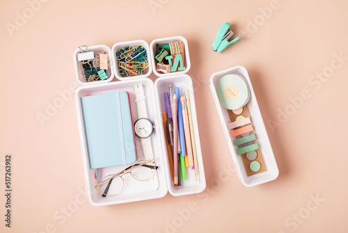 Desktop organization. Cleaning up messy stationary in plastic organizers for office and home desk photo