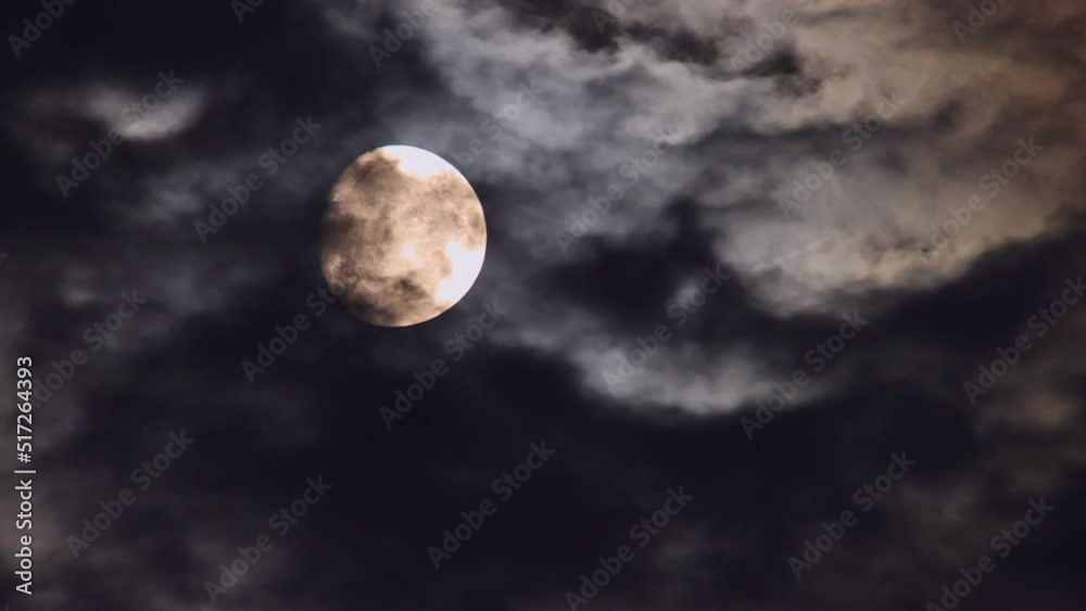 Bewitching moon moving through dark, mysterious nighttime clouds.
