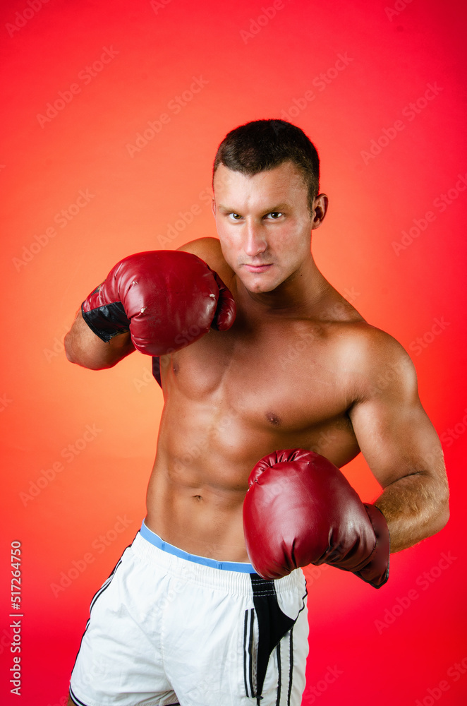 Young attractive boxer posing in the studio.
