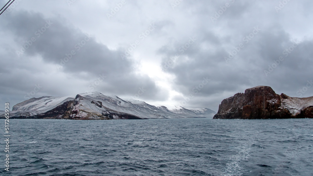 Snow dusted mountains around the pass at the entrance to the crater bay in Deception Island, Antarctica Snow dusted mountains around the pass at the entrance to the crater bay in Deception Island, Antarctica