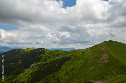 Picturesque Carpathian Mountains landscape with steep green slopes on mountain ridge beneath a sky with clouds 