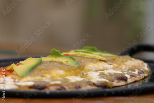 huarache antojito mexicano frito con carne, frijol y salsas verde y roja acompañado de queso y aguacate photo