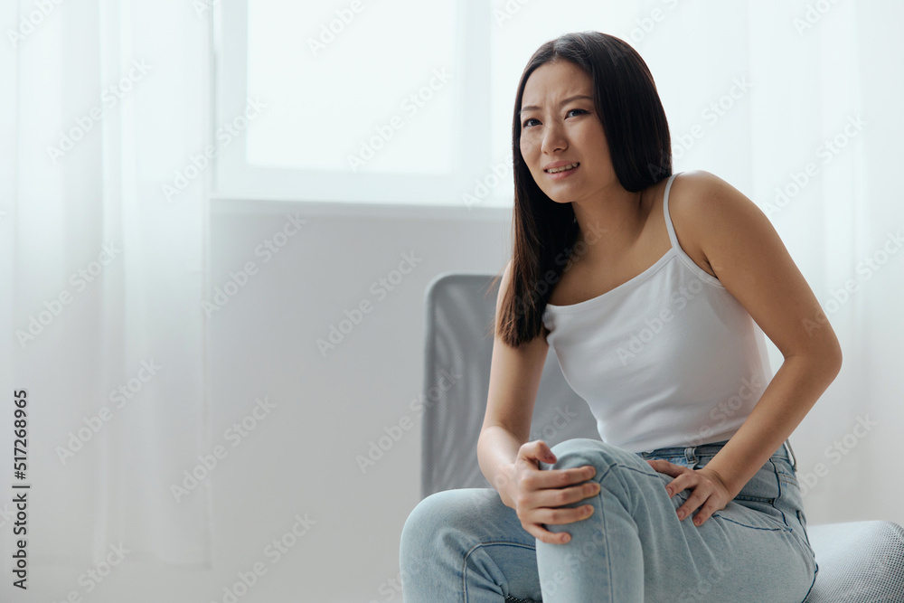 Cramp Broken Toe Broken Bone in Leg. Tormented suffering tanned beautiful young Asian woman touch leg at home interior living room. Injuries Poor health Illness concept. Cool offer Banner Cramp Broken Toe Broken Bone in Leg. Tormented suffering tanned beautiful young Asian woman touch leg at home interior living room. Injuries Poor health Illness concept. Cool offer Banner