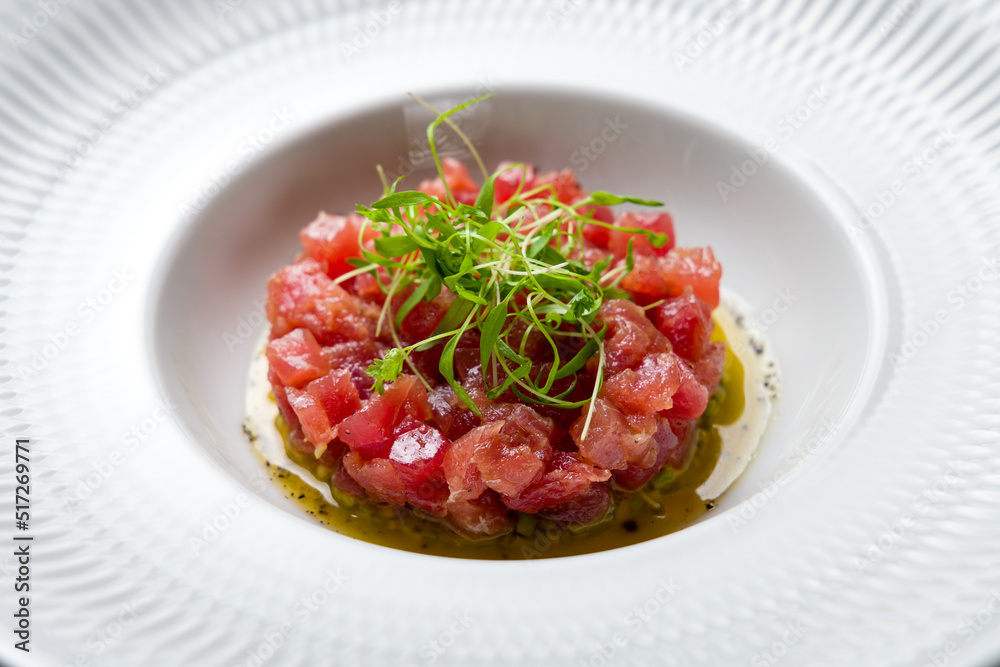 Tuna tar tar with avocado on a white plate macro close up Tuna tar tar with avocado on a white plate macro close up