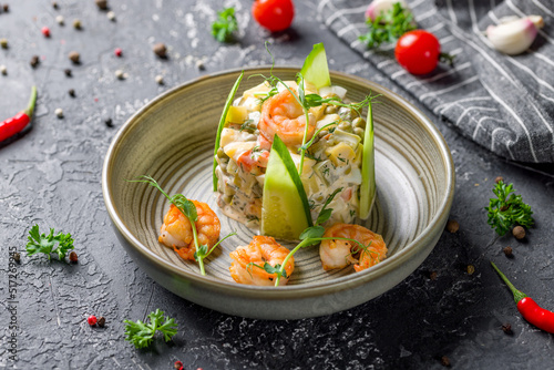 salad olivier with shrimps on plate on grey table photo