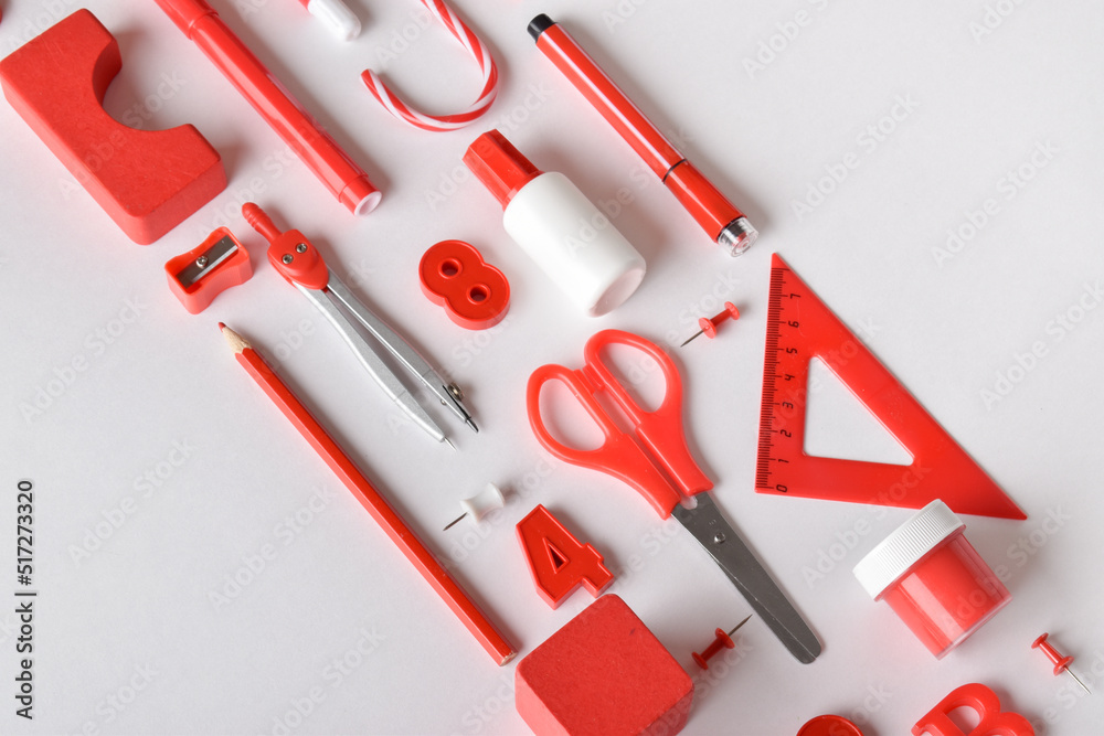 Various stationery of red color in the center on a diagonal on a white background. Various stationery of red color in the center on a diagonal on a white background.