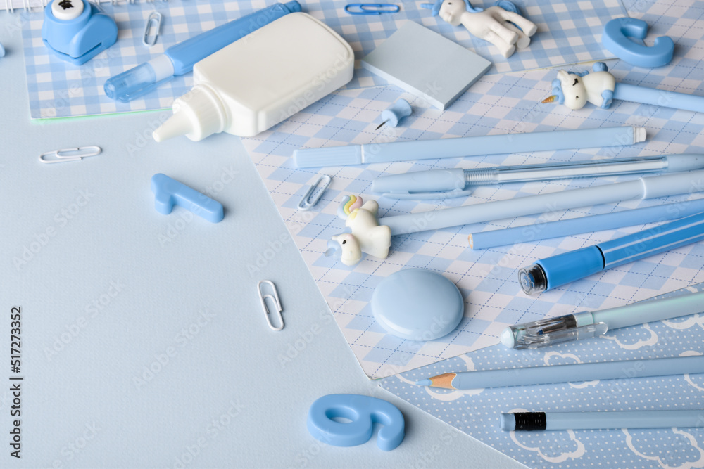 Close-up of various light blue stationery lying on the side on a light blue background. Close-up of various light blue stationery lying on the side on a light blue background.