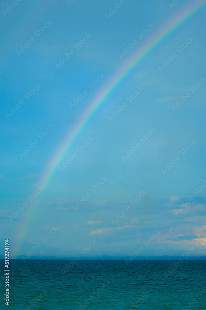 Calm blue seascape scenery with rainbow in the background in Pulau Besar, Mersing, Johor, Malaysia Calm blue seascape scenery with rainbow in the background in Pulau Besar, Mersing, Johor, Malaysia
