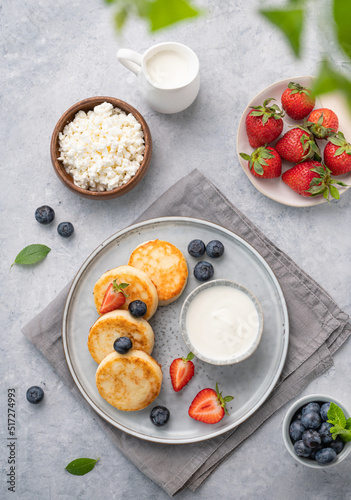 Cottage cheese pancakes with mint, blueberries and strawberries on a gray background. Healthy and delicious breakfast. Top view