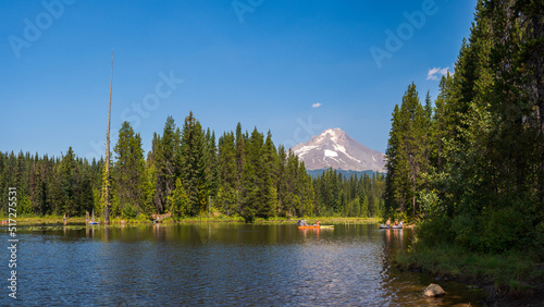 View of Mt. Hood Topped with Snow and Recreational Camping Area with Lake on Bright Sunny Day Surrounded by Wilderness