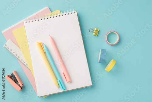 Back to school concept. Top view photo of colorful stationery planners pens ruler adhesive tape binder clip and mini stapler on isolated pastel blue background