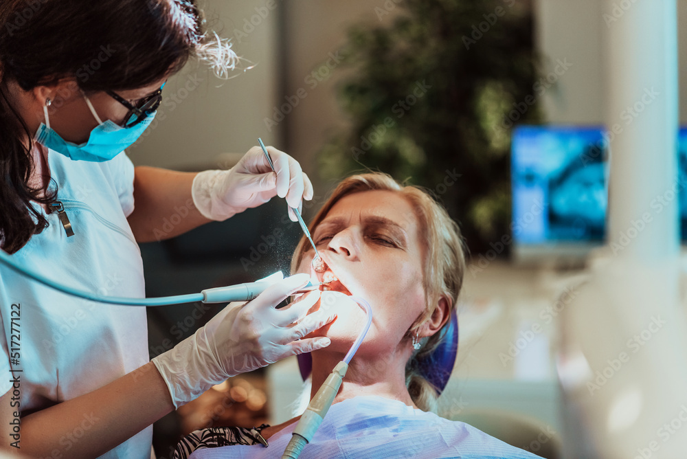 A dentist in a modern dental practice performs jaw surgery on an elderly patient A dentist in a modern dental practice performs jaw surgery on an elderly patient