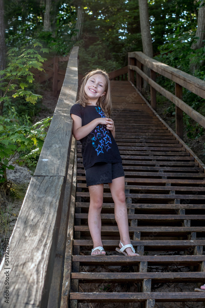 girl standing on steps on her way down to the beach girl standing on steps on her way down to the beach
